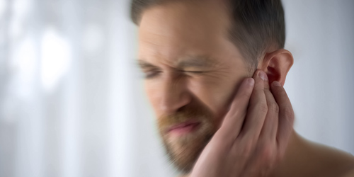 Tinnitus kann sich in vielem Äußern: Klopfen, Pfeifen und Co. Mann mit Tinnitus schmerzen