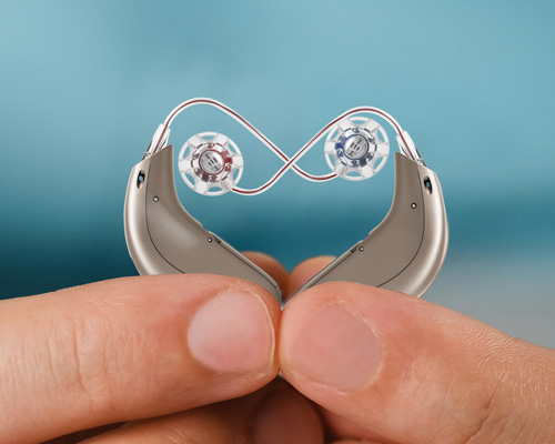 Zwei Hörgeräte deren Schläuche ein Herz formen