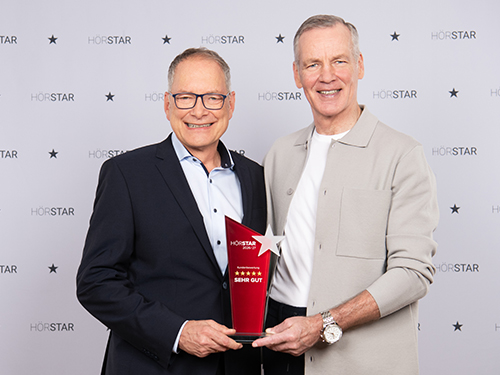 Henry Maske überreicht Georg Jaspert den Pokal bei der HörStar-Verleihung